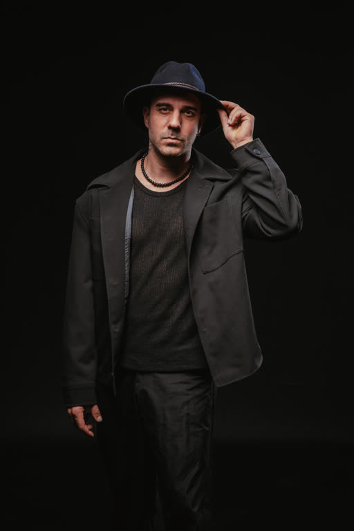 Juanjo Vivancos con chaqueta oscura y sombrero negro, retrato editorial.